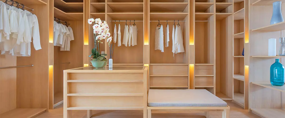walk-in closet system made of wood, natural wood color, with seat area
