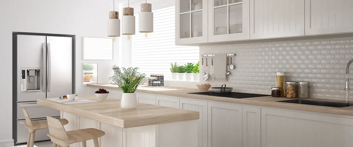 Modern Scandinavian kitchen design with white cabinets, light wood countertops, pendant lighting, and stainless steel refrigerator.