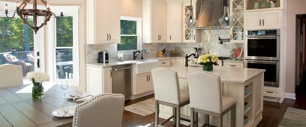 Elegant transitional kitchen with white cabinets, double oven, farmhouse sink, and large island with seating