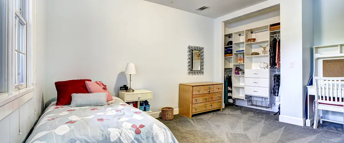 Open closet system in a kid’s bedroom with shelves, drawers, and hanging space